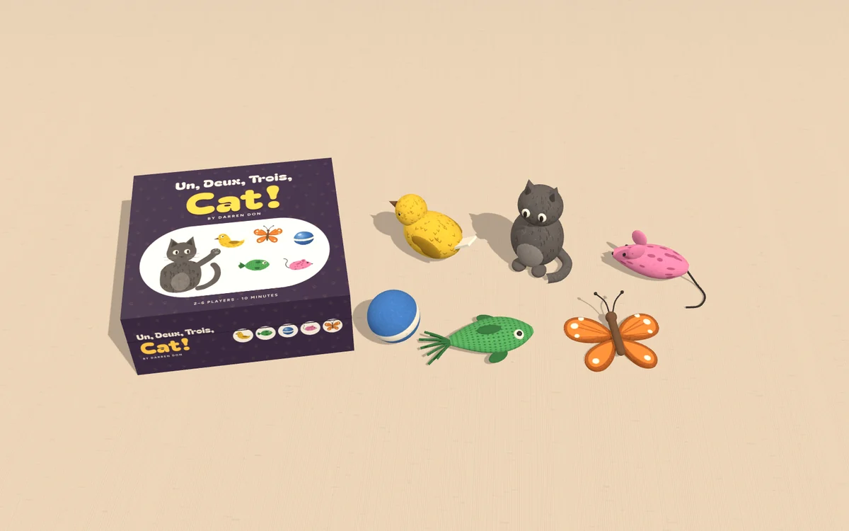 Un, Deux, Trois, Cat! mockup: the plum box beside five felt cat toys and a felt cat on a linen cloth.